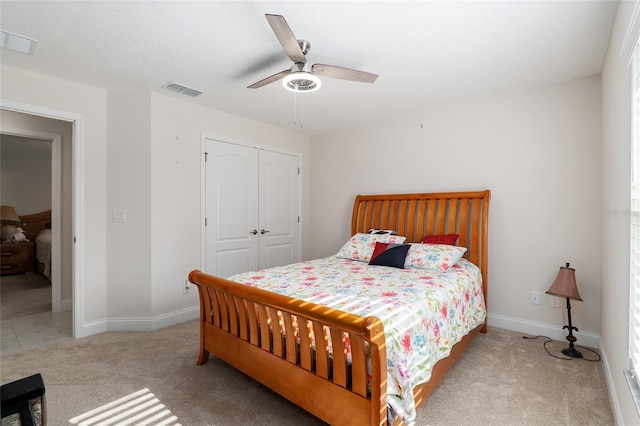 bedroom featuring ceiling fan, light colored carpet, and a closet