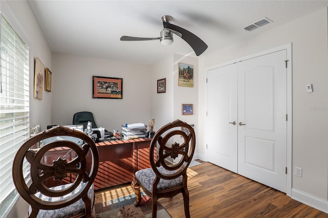 home office with ceiling fan and dark hardwood / wood-style floors