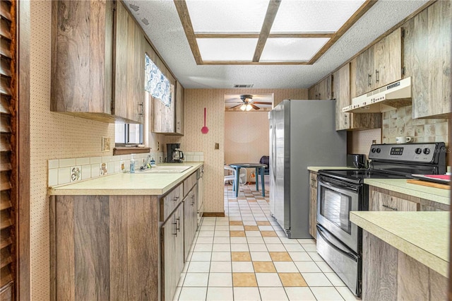 kitchen featuring stainless steel fridge, black range with electric cooktop, ceiling fan, sink, and light tile patterned floors