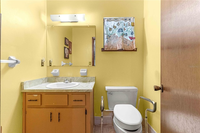 bathroom with tile patterned flooring, vanity, and toilet