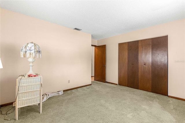 carpeted bedroom featuring a textured ceiling and a closet