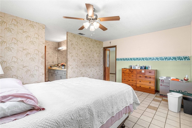 bedroom with ceiling fan, light tile patterned floors, and a textured ceiling