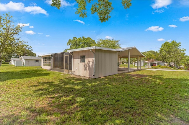 back of property with a lawn and a sunroom