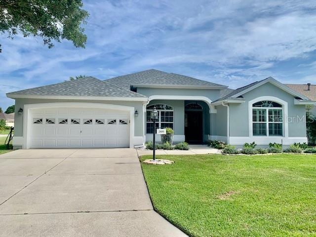 ranch-style house featuring a garage and a front lawn