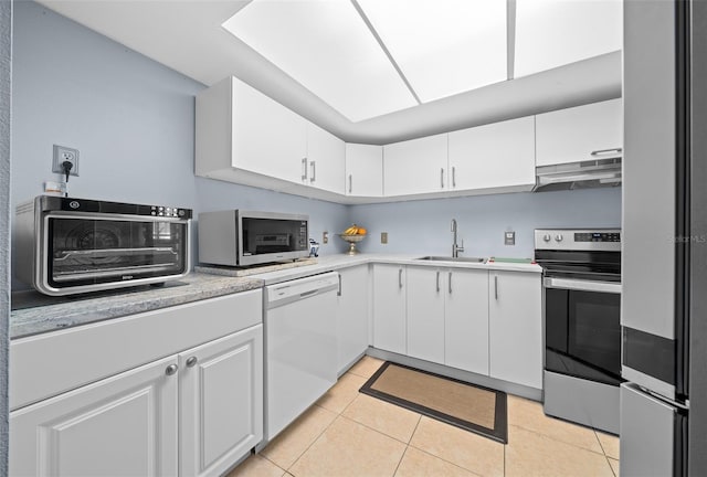 kitchen with light tile patterned flooring, sink, white cabinets, and stainless steel appliances