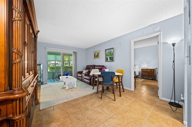 living room with light tile patterned floors, baseboards, and a textured ceiling