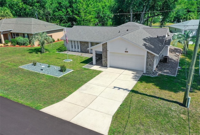 ranch-style house with a garage, stone siding, a front yard, and central air condition unit