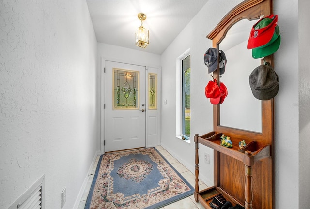 doorway featuring baseboards and light tile patterned flooring