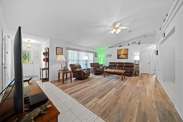 living area with visible vents, vaulted ceiling, a ceiling fan, and light tile patterned flooring