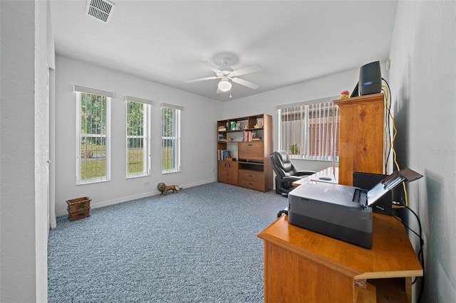 carpeted office space featuring a ceiling fan, visible vents, and baseboards