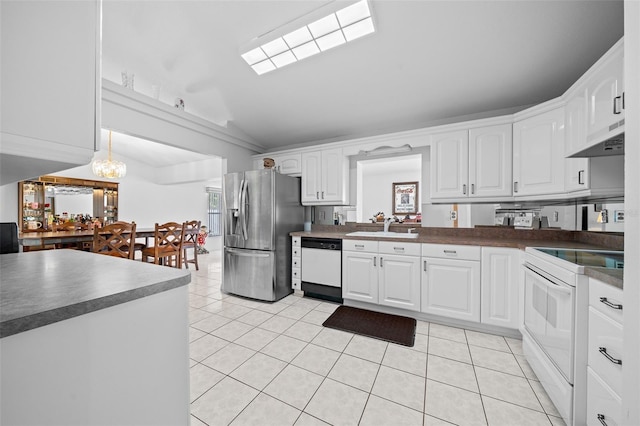 kitchen with light tile patterned floors, under cabinet range hood, white appliances, a sink, and white cabinets