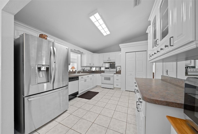 kitchen featuring dark countertops, visible vents, light tile patterned flooring, a sink, and white appliances