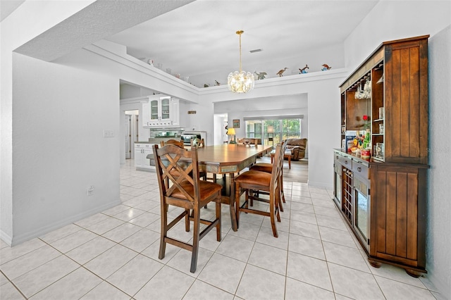 dining space with light tile patterned floors, baseboards, visible vents, and a notable chandelier