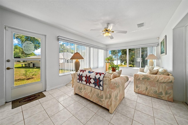 sunroom / solarium with a wealth of natural light, visible vents, and a ceiling fan