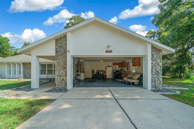 garage with concrete driveway and freestanding refrigerator