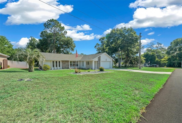 single story home with a front lawn, concrete driveway, fence, and an attached garage