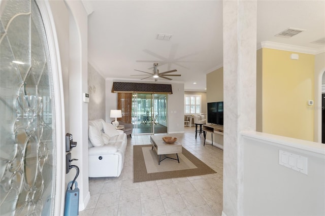 tiled living room featuring ceiling fan and crown molding