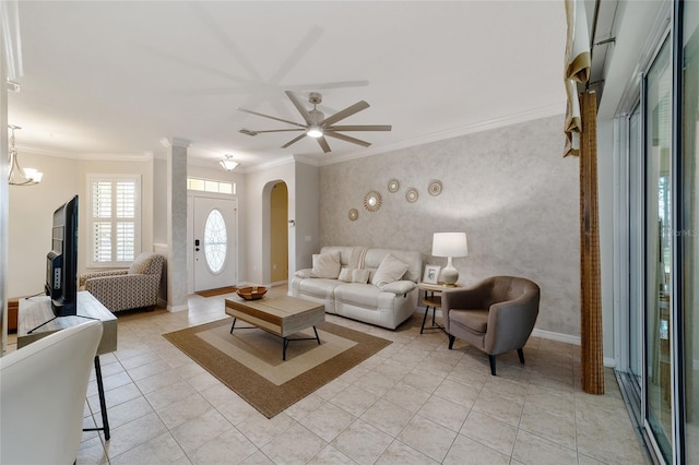 living room with light tile patterned floors, ceiling fan with notable chandelier, and ornamental molding