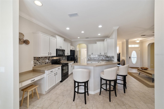 kitchen featuring white cabinetry, a kitchen breakfast bar, kitchen peninsula, light tile patterned flooring, and black appliances