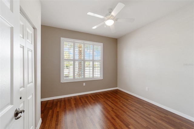 spare room with ceiling fan and dark wood-type flooring