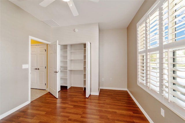 unfurnished bedroom featuring hardwood / wood-style flooring, ceiling fan, and a closet