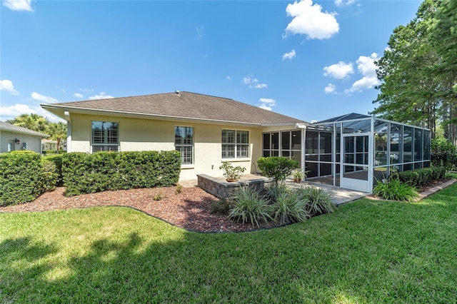 rear view of property featuring a lanai and a lawn