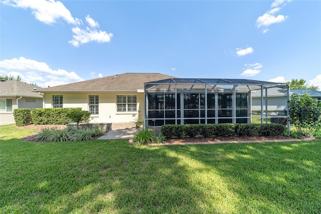 rear view of house featuring a lawn and a lanai