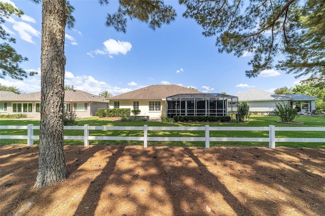 ranch-style home featuring a front lawn and a sunroom