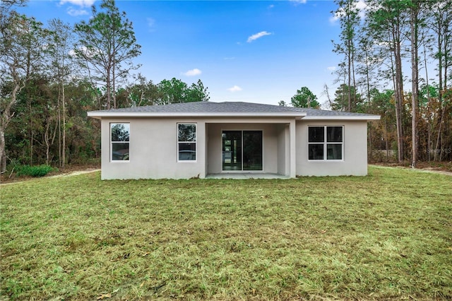 back of property featuring a lawn and a patio area