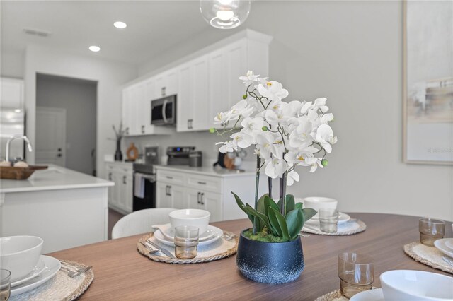 dining space featuring hardwood / wood-style flooring and sink