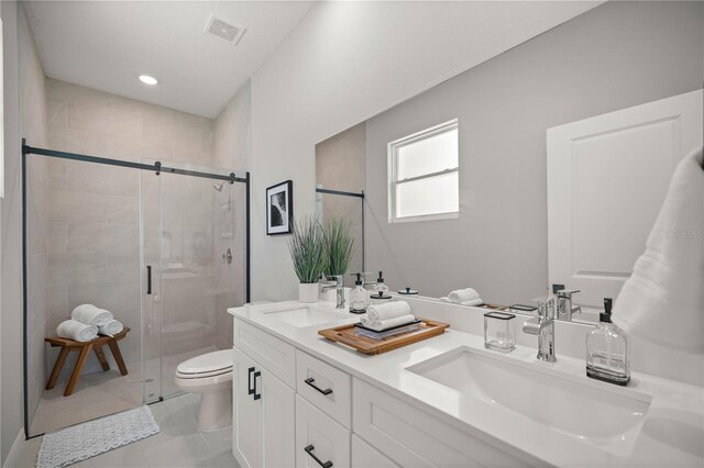 bathroom with toilet, vanity, tile patterned floors, and an enclosed shower