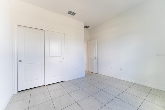 unfurnished bedroom featuring a closet and light tile patterned flooring