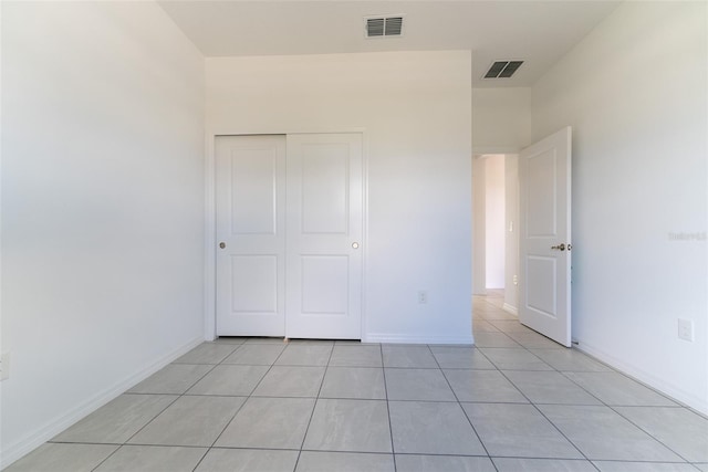 unfurnished bedroom with a closet and light tile patterned floors