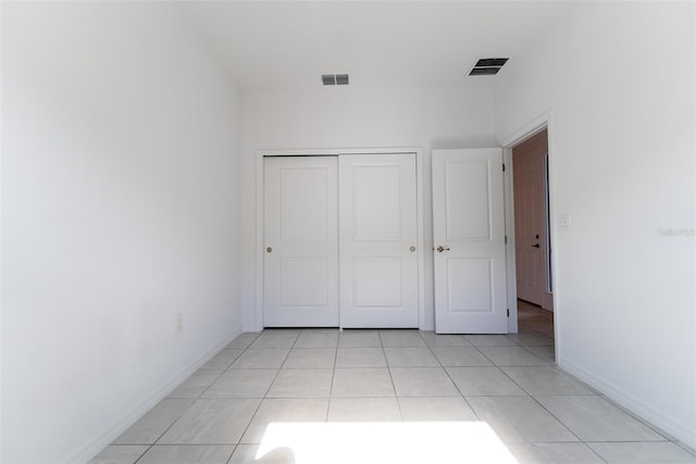 unfurnished bedroom with a closet and light tile patterned floors