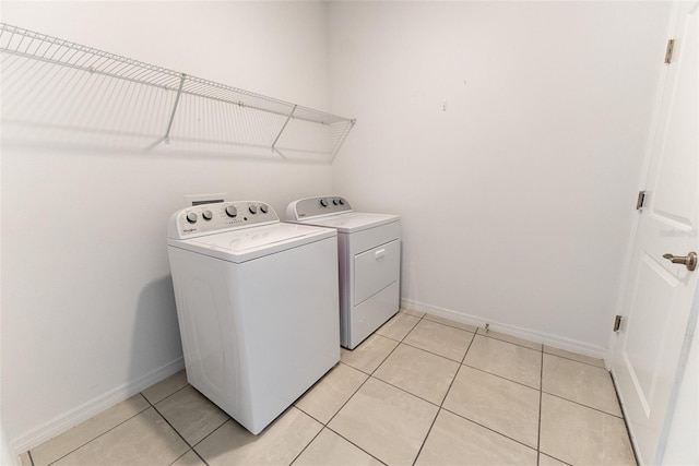 laundry room with independent washer and dryer and light tile patterned flooring