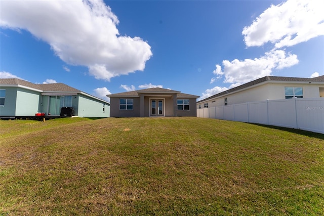 rear view of property featuring a yard