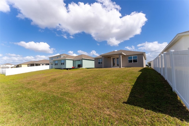 rear view of house featuring a lawn