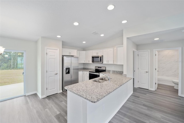 kitchen featuring light stone countertops, light wood-type flooring, white cabinetry, kitchen peninsula, and stainless steel appliances