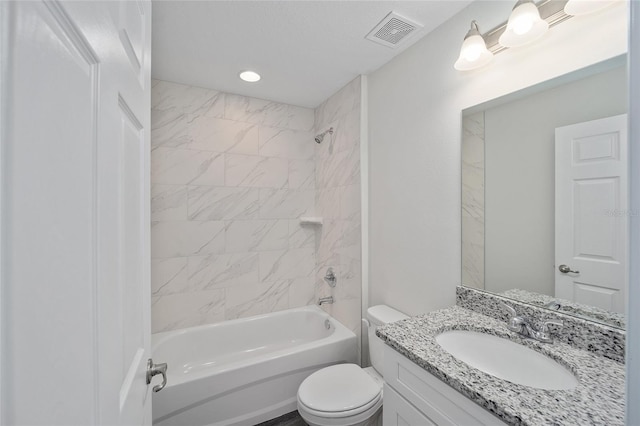 full bathroom featuring vanity, tiled shower / bath combo, and toilet