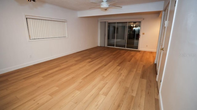 spare room with ceiling fan, light wood-type flooring, and a textured ceiling