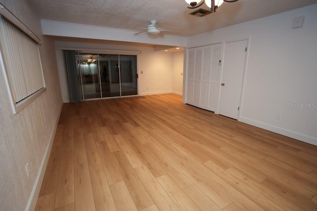 spare room with ceiling fan, light hardwood / wood-style floors, and a textured ceiling