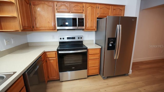 kitchen with light hardwood / wood-style flooring, stainless steel appliances, and sink