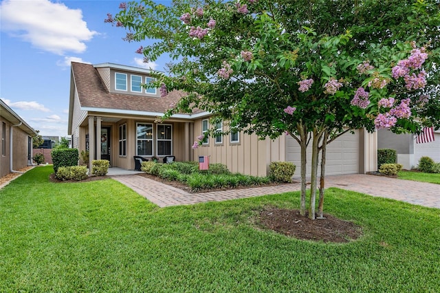 view of front of home with covered porch, a garage, and a front lawn