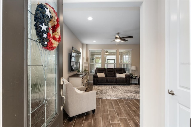 living room with dark hardwood / wood-style flooring and ceiling fan