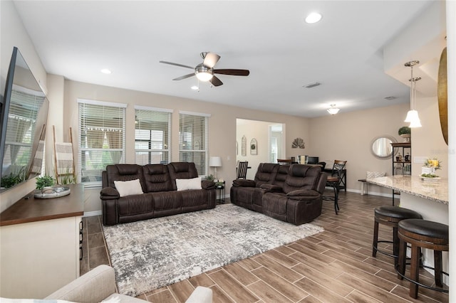 living room featuring ceiling fan and hardwood / wood-style floors