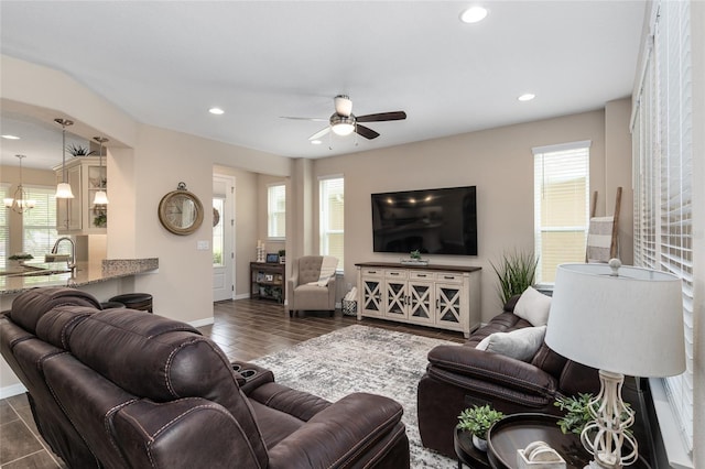 living room with dark hardwood / wood-style flooring, ceiling fan, and sink