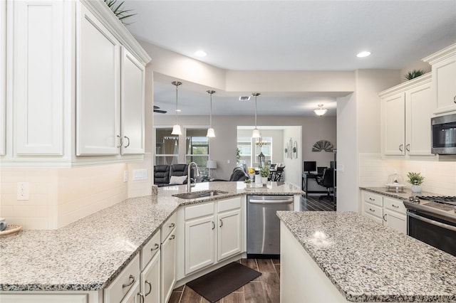 kitchen with light stone countertops, sink, appliances with stainless steel finishes, and dark wood-type flooring