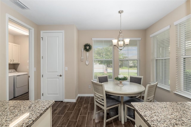 dining area with independent washer and dryer, an inviting chandelier, and dark wood-type flooring