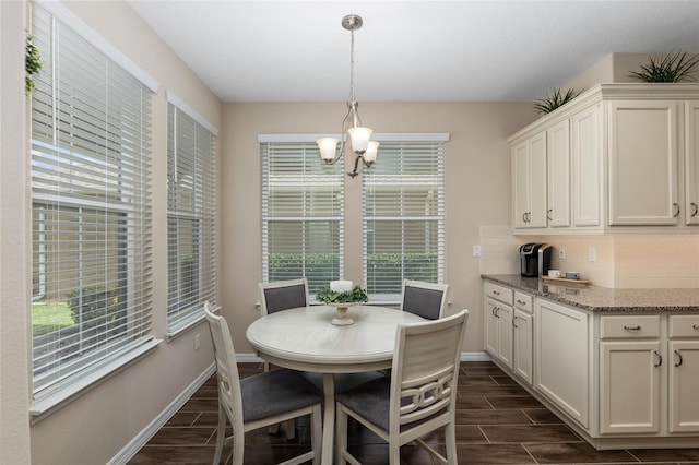 dining room with dark hardwood / wood-style floors and a chandelier