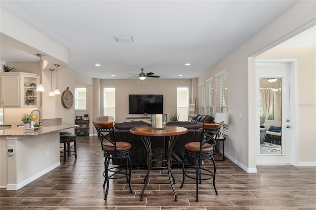 dining room with dark hardwood / wood-style flooring and ceiling fan